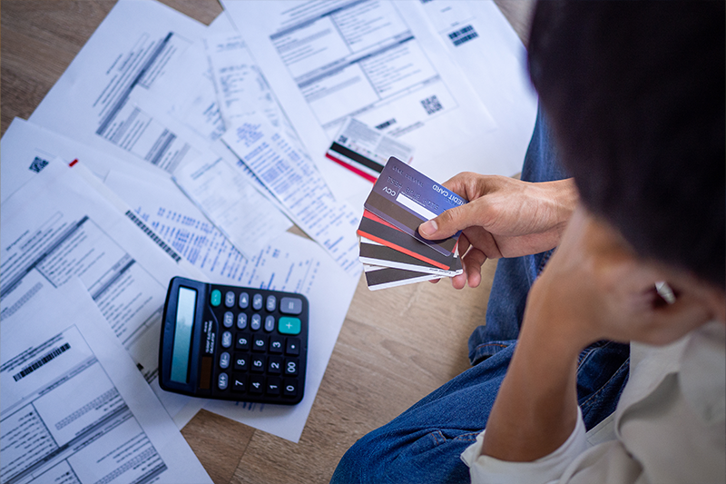 Business people are stressed about credit card debt and many bills on the floor