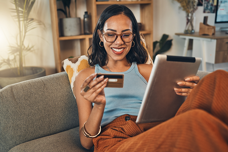 Ecommerce, credit card and woman on a couch, tablet or payment with an order, home or online shopping