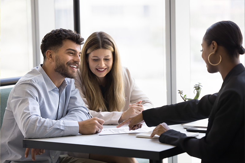 Happy couple engaged in conversation with financial consultant
